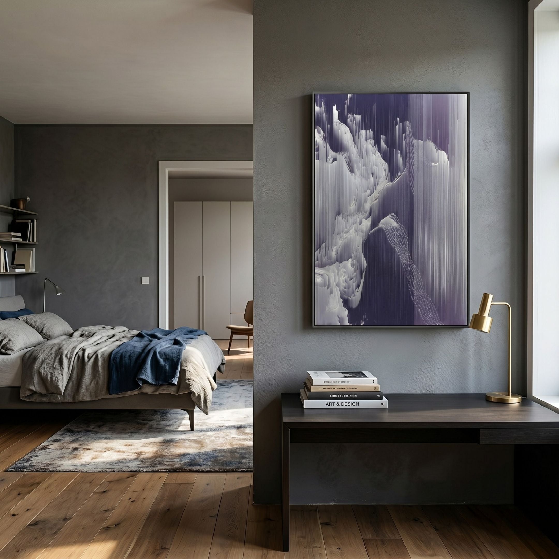 A modern bedroom with gray walls features a cozy bed, rug, and desk with a gold lamp and books. Above the desk hangs Giant Sculptures’ Aerolune Violet & Silver Mistform Rope 3D Wall Art, bathed in natural light from a nearby window.