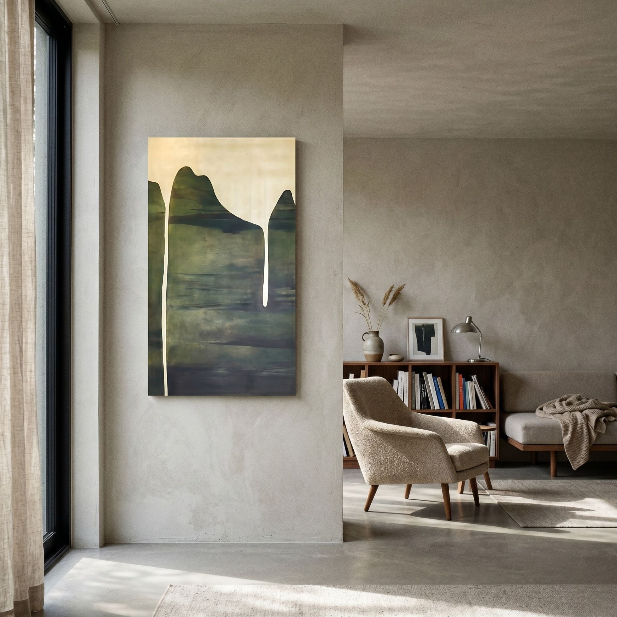 A modern living room in neutral tones features the Seralyon Green Drip Peak Vertical Canvas Wall Art by Giant Sculptures, a cozy beige armchair, bookshelves, and a floor lamp. Light pours in from a tall window.