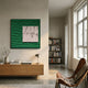 A modern living room featuring a leather chair, wooden sideboard, table lamp, minimalist decor, bookshelves, and large windows is enhanced by the Loftera Green Sculpted Fabric & Abstract Canvas 3D Wall Art by Giant Sculptures for added depth and style.