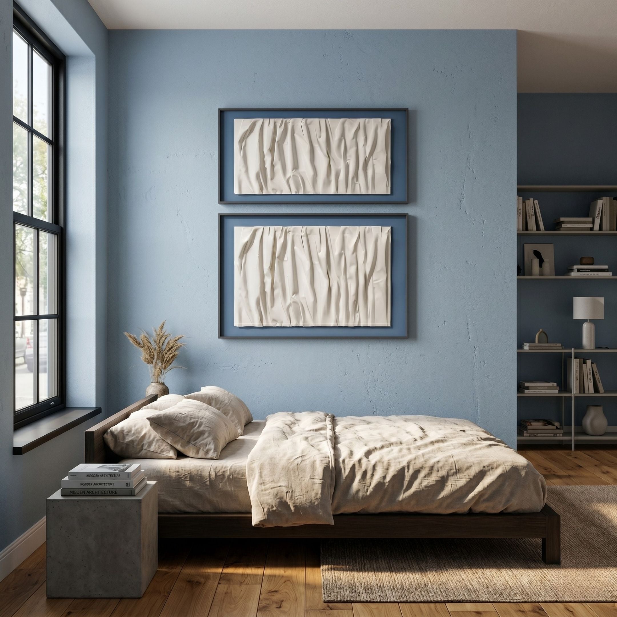 A cozy bedroom with light blue walls, a large window, a neatly made bed with beige bedding, and Giant Sculptures' Foldara Cream & Blue Draped Paper Dual-Panel 3D Wall Art above the bed; shelves with books and decor sit in the corner.