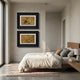 A modern, minimalist bedroom features a wooden bed with white bedding, a rug, and a nightstand with a lamp. Above the bed hang two Kansora Bamboo Brushwork Classic 2-Set Framed Wall Art pieces by Giant Sculptures, adding elegance to the bright space.