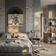 A cozy, sunlit children's bedroom features moon and star wallpaper, a bed of plush toys and books, the Giant Sculptures Cuddiloft Elephant Plush Display 3D Wall Art, a framed elephant picture, bookshelves, and soft decorative hallway lights.