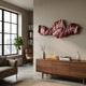 Vellun Wave Rosewood Sculptural 3D Wall Art with layered maroon and blush ribbons mounted above a walnut sideboard in a modern living room.
