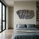 Stratava Arcstone Layered Wood Carving 3D Wall Art by Giant Sculptures, fan-shaped grey and brown arcs mounted above a bed with grey linen bedding.