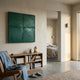 Giant Sculptures Terracrecta Deep Green Painted Textured Square 3D Wall Art displayed above a wooden bookshelf in a minimalist room with a leather chair.