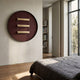 Straylight Terracotta Red Tiered Bar Round 3D Wall Art by Giant Sculptures displayed in a sunlit bedroom above wood flooring beside a linen-covered bed.