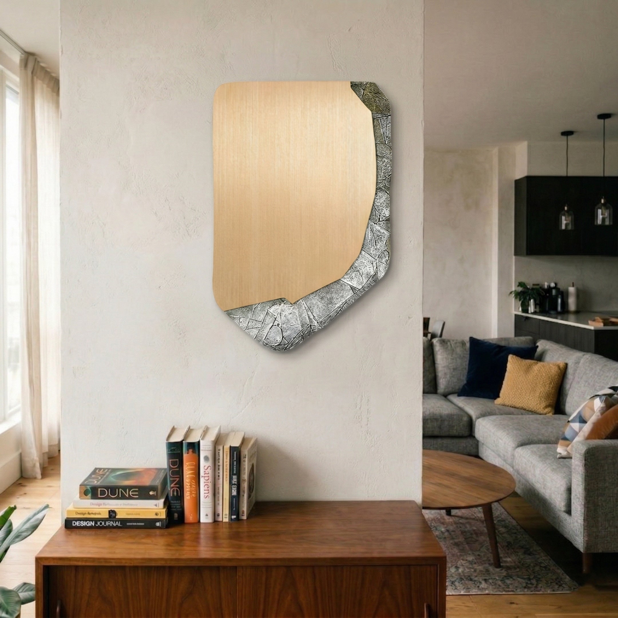 Gildrift Gold Steel & Silver Crackle Edge Textured 3D Wall Art by Giant Sculptures mounted on a textured beige wall in a living room, showing brushed gold stainless steel with an irregular silver crackle-textured edge, above a wooden console with books.