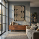 Curvanta Bronze Loop Geometric 3D Wall Art by Giant Sculptures mounted on a grey wall above a walnut sideboard with brass lamp in a modern living room.