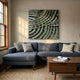 Rillora Sage Green Ribbed Wood Carving 3D Wall Art by Giant Sculptures mounted above a dark blue sectional sofa in a sunlit living room with a walnut coffee table and jute rug.
