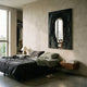 Arclunor Black Arch Relief Mirror 3D Wall Art by Giant Sculptures mounted above a low bed with green and charcoal linens in a textured plaster bedroom.