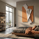 Arcluma Amber Folded Ribbon Leather 3D Wall Art by Giant Sculptures displayed above a wooden bed in a modern bedroom with concrete walls and city-view window.