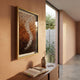 Spiravale Amber Gradient Floral Curl 3D Wall Art in a light-wood frame mounted on a terracotta hallway wall above a wooden console with vase and book.