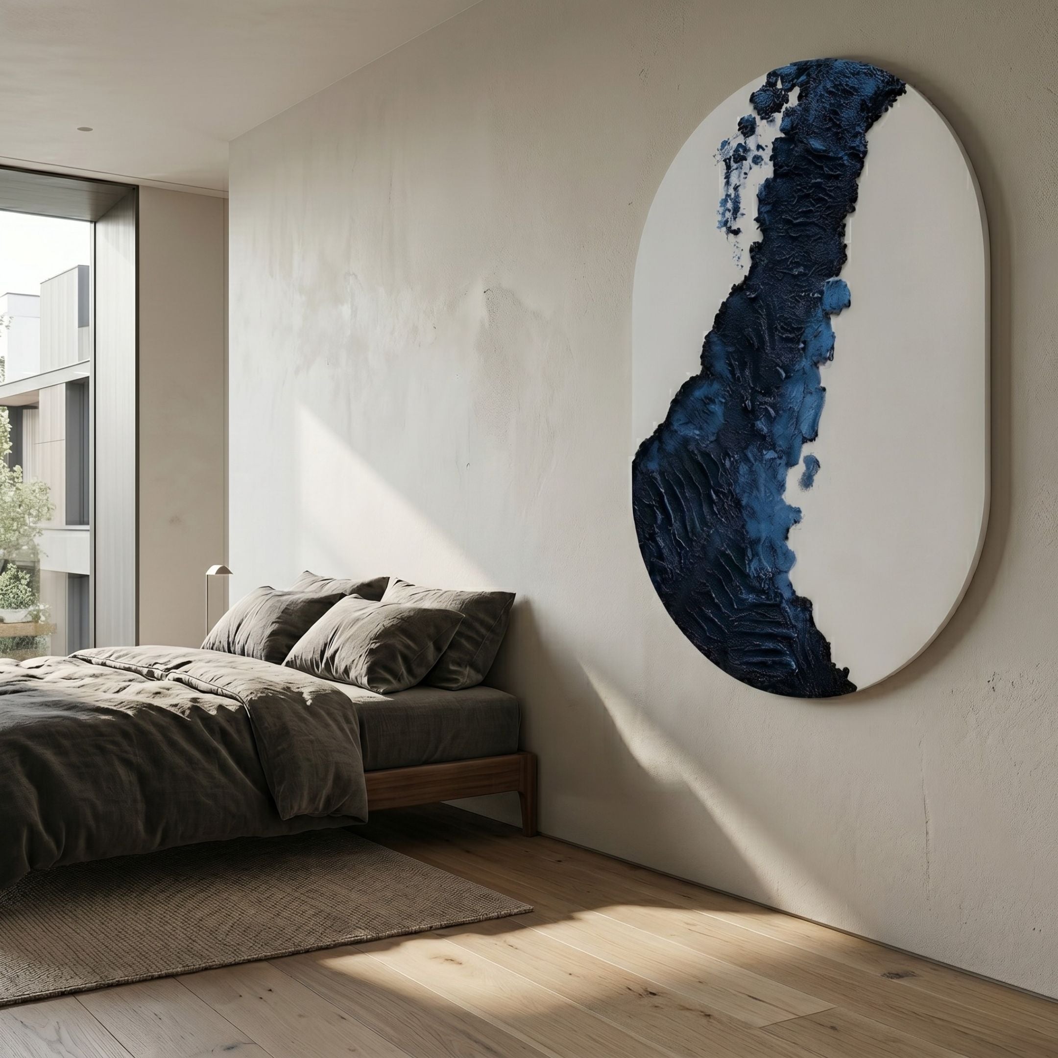 Orrica Midnight Blue Textured Relief 3D Wall Art by Giant Sculptures in oval form, mounted on a bedroom wall above a linen-dressed bed by a window.