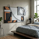 Struktura Bronze & Black Geometric Curve 3D Wall Art by Giant Sculptures mounted above a platform bed with grey linens, beside a black lamp and fiddle-leaf fig.