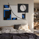Struktura Blue & Black Geometric Curve 3D Wall Art displayed above a wooden bed with linen bedding, beside open shelves of books in a sunlit bedroom.