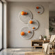Orbiora Orange Orb 4-Panel Concentric Sphere 3D Wall Art by Giant Sculptures displayed on a pale wall above a wooden console in a modern living room.