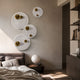 Orbiora Gold Orb 4-Panel Concentric Sphere 3D Wall Art by Giant Sculptures arranged on a bedroom wall above a bed with paper lantern lamp nearby.