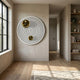 Orbiora IV Gold Duo Concentric Sphere 3D Wall Art by Giant Sculptures displayed in a minimalist hallway with oak flooring, a window, and built-in shelving.