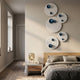 Orbiora Blue Orb 5-Panel Concentric Sphere 3D Wall Art mounted vertically above a wooden bedside table and bed in a modern bedroom.