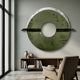 Zenithra Green Bamboo Landscape Circular 3D Wall Art by Giant Sculptures, a jade-green disc with bamboo motifs and black rods, above a wooden bookshelf.
