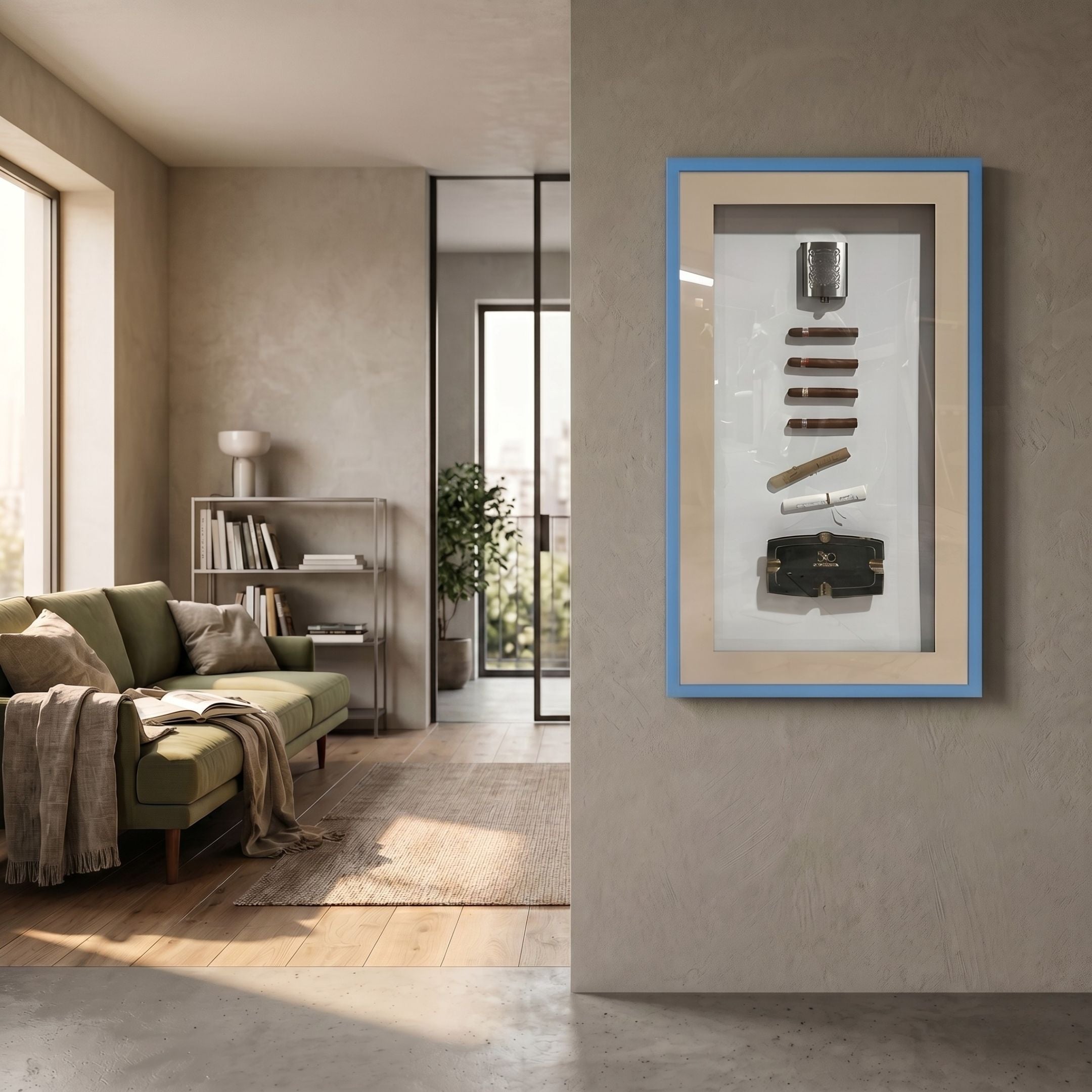 Vitara Ashtray & Rolled Cigars Framed 3D Wall Art by Giant Sculptures with blue border and cream backing, mounted in a neutral living room beside a green sofa.