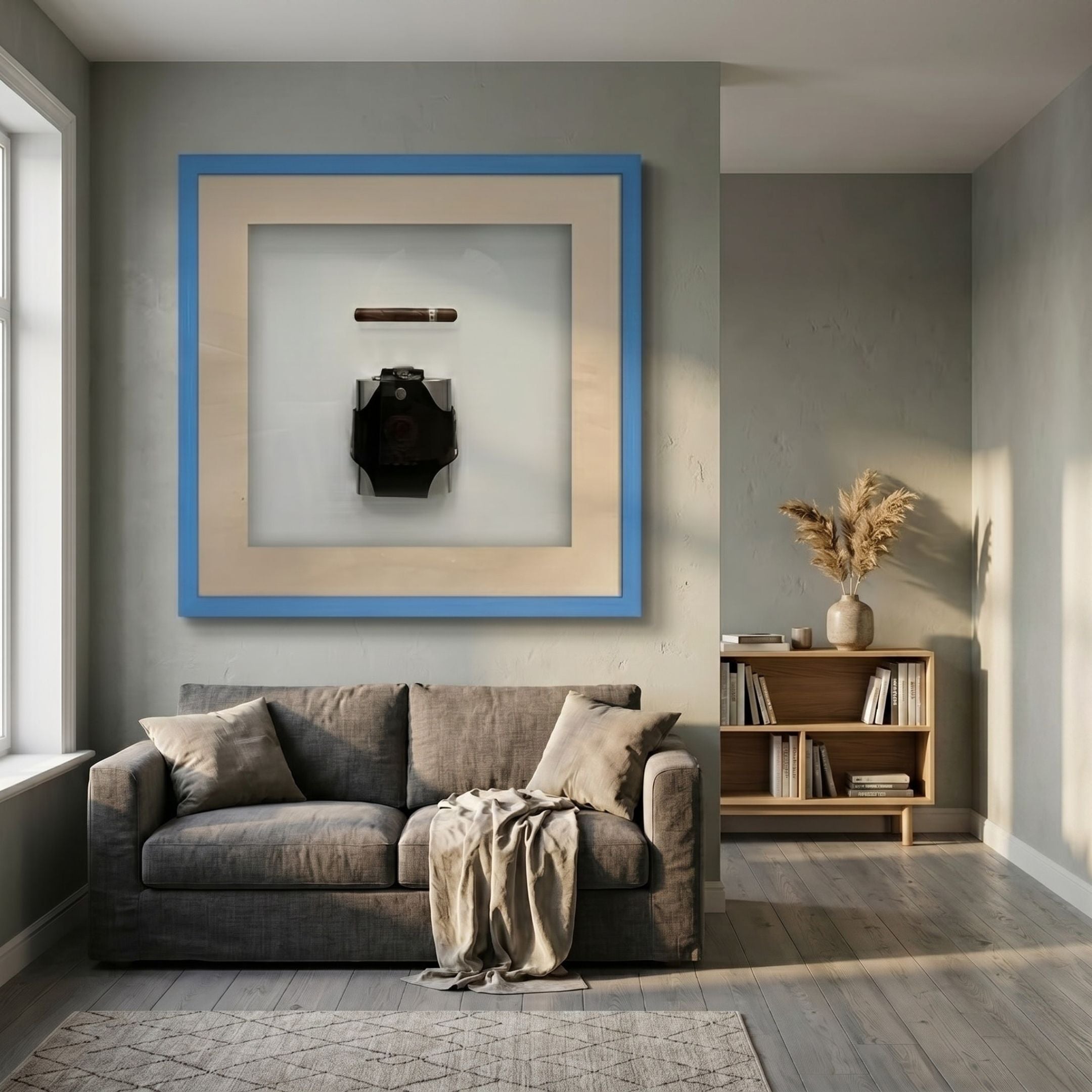 Vitara Black Hip Flask & Cigar Framed 3D Wall Art by Giant Sculptures displayed above a grey sofa in a living room with a wooden bookshelf.