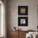 Artelis 2-Set Bird & Floral Pattern Framed Wall Art in black wood frames, hung vertically above a walnut sideboard with potted succulent and vase.
