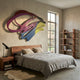 Cavoya Abstract Loops Multicolour Wall Art by Giant Sculptures in pink, blue, and yellow, mounted above a wooden bed in a modern bedroom with a tall window.