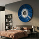 Solyra Cobalt Circular Textured Wood 3D Wall Art by Giant Sculptures displayed above a bed with peach bedding, beside a bookshelf in a modern bedroom.