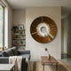 Solyra Bronze Circular Textured Wood 3D Wall Art with white central ring and radiating rays, mounted above a grey sofa in a minimalist living room.