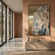 Aurista Botanical Flow Abstract Cotton Spray Wall Art by Giant Sculptures, mounted in a peach-toned hallway above a console with books, vase, and brass lamp.