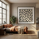 Nerava Organic Dots Black & Cream Abstract Wall Art displayed above a bed with terracotta linens in a Nordic-style bedroom with a leafy plant and large window.
