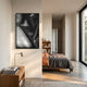 Rivara Obsidian Flow Hand-Painted Rope 3D Wall Art in black and white hung above a wooden nightstand in a sunlit modern bedroom with linen bedding.
