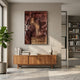 Gradalis Red Bronze Sculptural Metal 3D Wall Art mounted above a walnut sideboard with books in a sunlit modern living space with fiddle leaf fig and bookshelf.