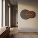 Solvia Brown & Grey Layered Geometry 3D Wall Art by Giant Sculptures, mounted in a hallway with a walnut console, showing overlapping grey disc and brown textured panel divided by a slim gold strip.