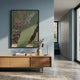 Metallura Deep Green Metallic Flow Abstract 3D Wall Art by Giant Sculptures displayed above a wooden sideboard with vase and lamp in a blue-walled hallway.