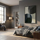 Striatura Black & Stone Grey Rope Abstract 3D Wall Art by Giant Sculptures displayed on a grey bedroom wall above a linen-dressed bed near a floor lamp.