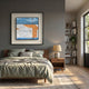 Aerolith Blue Horizon Abstract Textured Framed Wall Art with blue, white, and orange mountain motif hung above a wood bed in a grey-walled bedroom.