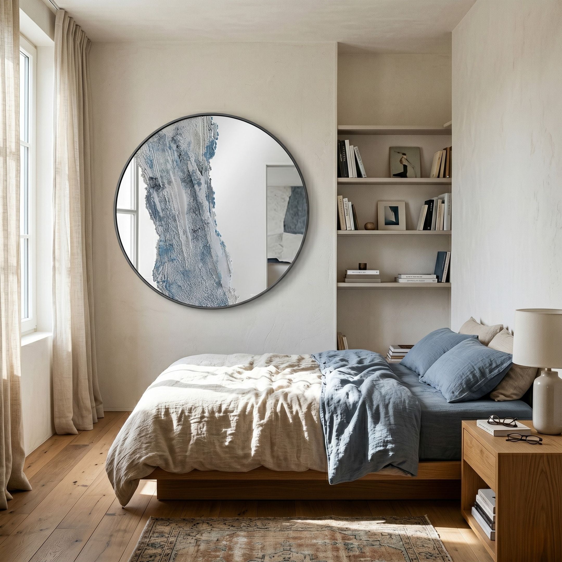 Erosian Silver Cascade Textured Round Mirror by Giant Sculptures mounted above a wooden bed with linen bedding, beside built-in shelves in a sunlit bedroom.