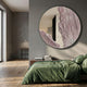 Giant Sculptures Erosian Blush Vein Textured Round Mirror 3D Wall Art mounted on a grey bedroom wall above a green linen bed and stacked books.