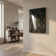 Arclunor Black Triangle Relief Mirror 3D Wall Art mounted on a pale wall in a hallway with wooden flooring and a low bookshelf in the background.