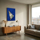 Arclunor Cobalt Blue Triangle Relief Mirror 3D Wall Art mounted above a teak sideboard with brass lamp and dried grasses in a sunlit modern living room.