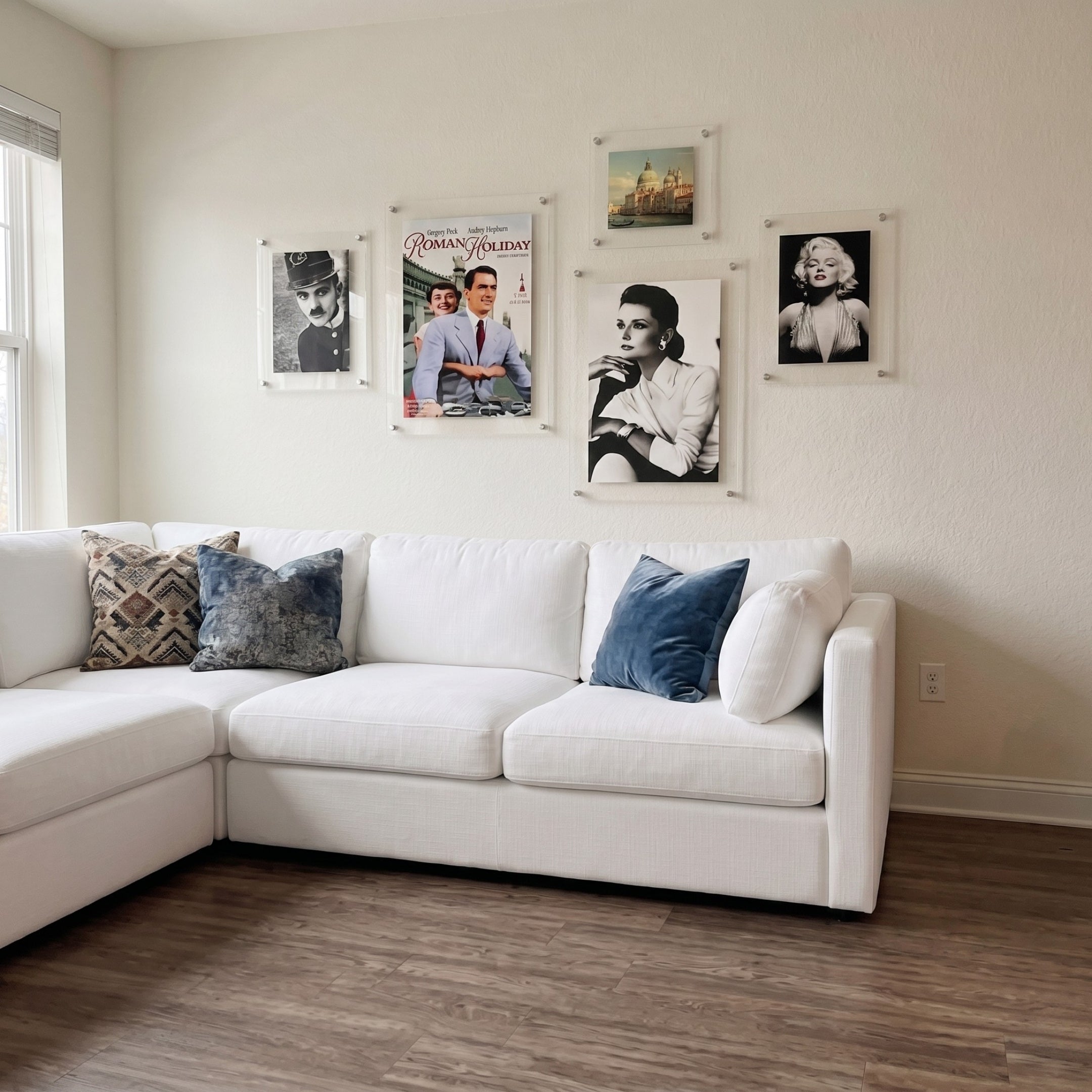 CineLuxe Classic Icons Retro 5-Panel Acrylic Wall Art by Giant Sculptures displayed above a white sectional sofa, featuring five floating acrylic panels with black-and-white portraits and a color movie poster.