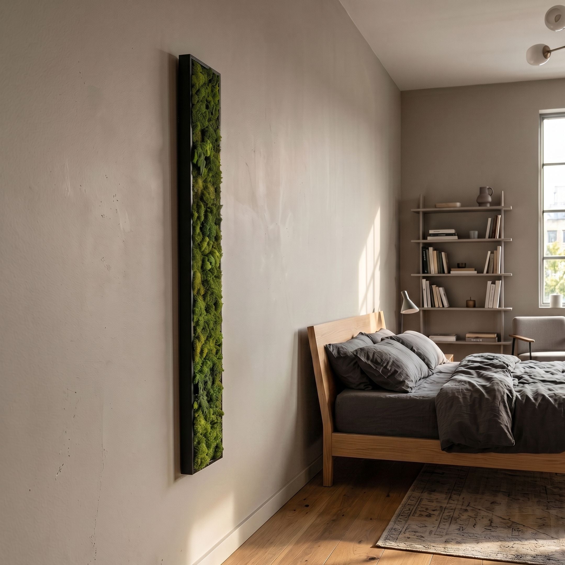 Verdura Vertical Green Moss Strip 3D Wall Art by Giant Sculptures, a tall black-framed preserved moss panel mounted on a light wall beside a wooden bed.