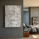 Averis Monochrome Swirl Relief Abstract 3D Wall Art by Giant Sculptures displayed on a dark grey bedroom wall beside a linen bed and wooden bookshelf.