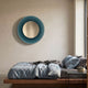 Coreva Teal Acrylic & Gold Mirror Round 3D Wall Art by Giant Sculptures mounted above a wooden platform bed with linen bedding in a modern bedroom.