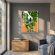 Truvira Chapel Path Moss Framed 3D Wall Art by Giant Sculptures, featuring a green moss tree and white chapel on orange, displayed above a wooden cabinet beside a blue armchair.