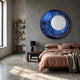 Solara Cobalt Blue White Disc & Metal Ring 3D Wall Art mounted above a bed with terracotta linen in a concrete-walled bedroom with bookshelf nearby.