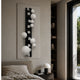 Orbevo Black & White Sphere Vertical 3D Acrylic Wall Art by Giant Sculptures displayed above a bedside table beside a bed and dark wood bookshelf.