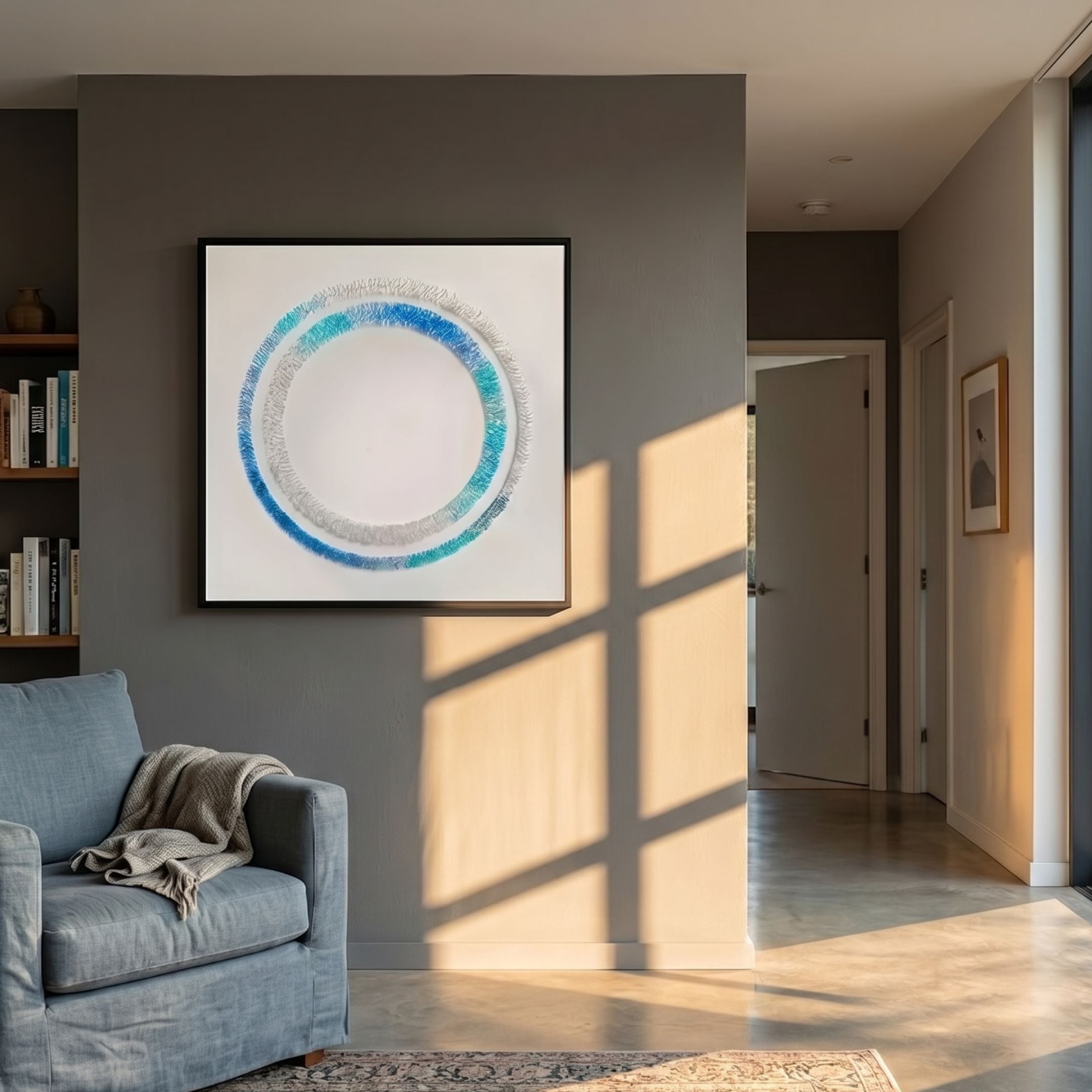Virelium Azure Gradient Double Ring Acrylic 3D Wall Art by Giant Sculptures displayed on a grey wall above a blue armchair in a sunlit modern living room.